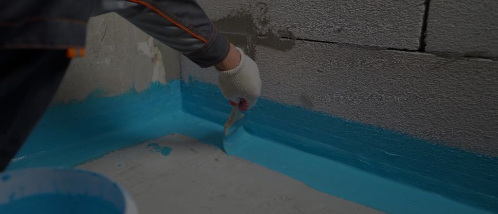 Bathroom renovation at the waterproofing stage, with waterproof membrane being applied to walls and floor.