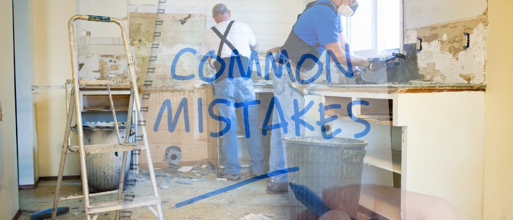 Two workers renovating a bathroom — one removing tiles and another handling old pipes, overlaid with a translucent image of a notebook labeled “Common Mistakes,” representing frequent bathroom renovation errors to avoid.